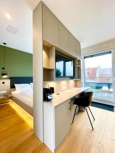 a bedroom with a bed and a desk with a chair at zeitwohnhaus SUITE-HOTEL & SERVICED APARTMENTS in Erlangen