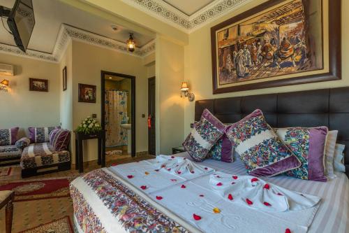 a bedroom with a large bed with colorful pillows at Le Caspien Boutique Hotel in Marrakech