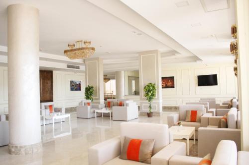 a lobby with white couches and tables at Gloria Aqua Park Hotel in Aswan