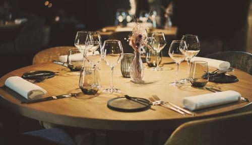 a wooden table with wine glasses and napkins at Domaine Sur Les Sarts in Ohey