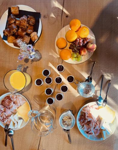 a wooden table with plates of food and drinks at Domaine Sur Les Sarts in Ohey
