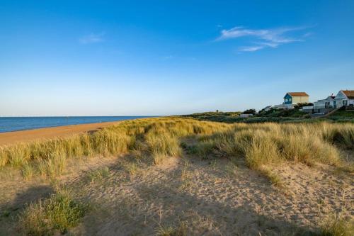 a sandy beach with houses and the ocean at Cozy Holiday Home in Anderby Creek in Anderby