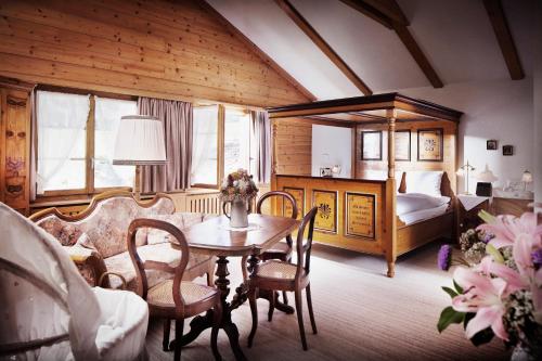 Zimmer mit einem Tisch und Stühlen sowie einem Schlafzimmer in der Unterkunft Landgasthof Ruedihus in Kandersteg
