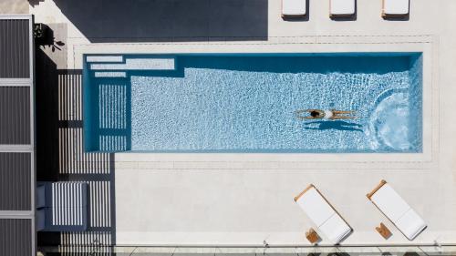 a person swimming in a swimming pool at Artemis Villa, Beachfront Retreat with Heated Pool, By ThinkVilla in Tavronitis
