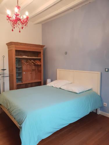 une chambre avec un grand lit et un lustre dans l'établissement Villa Marcel Spa Sauna Billard Piscine 25mn de Bordeaux, à Cérons