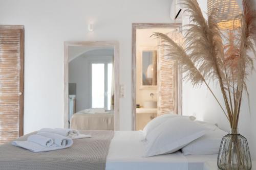 a white bedroom with a bed with towels on it at Naxos Sandastic in Agios Prokopios