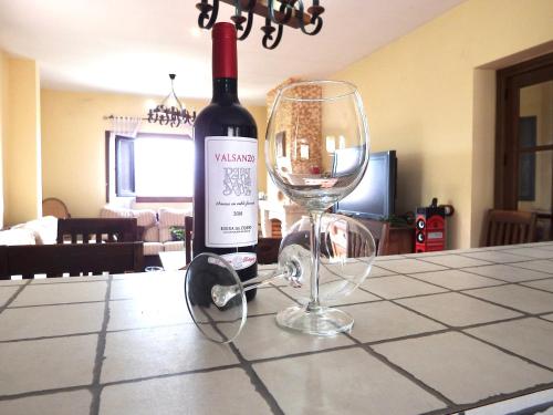 a bottle of wine and a glass on a table at Paradise in Aldea del Fresno