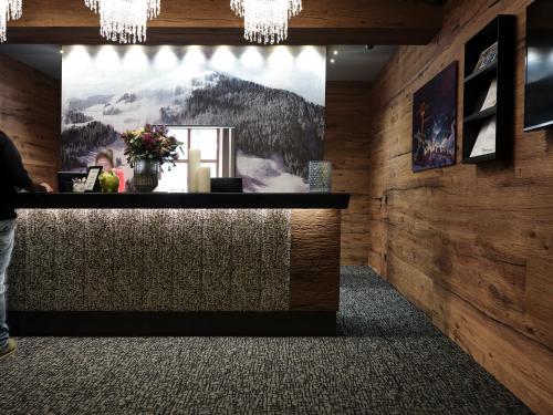 a bar in a restaurant with a picture on the wall at Hotel Hasenauer 4 Sterne Superior in Saalbach Hinterglemm