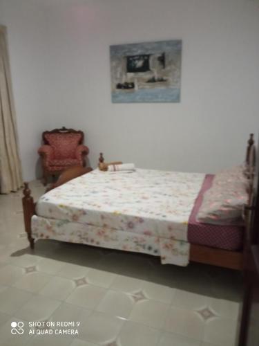 um quarto com uma cama e uma cadeira em Cosy bedroom near University em Il-Gżira