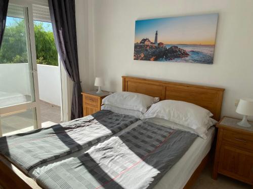 1 dormitorio con 1 cama con una foto en la pared en Bahia De Casares, en Estepona