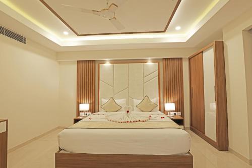 a bedroom with a large white bed with two lamps at Krishnavalsam Regency in Guruvāyūr