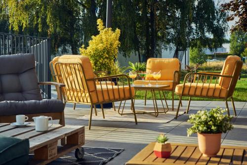 a group of chairs and a table on a patio at Novotel Roissy Saint Witz in Saint-Witz
