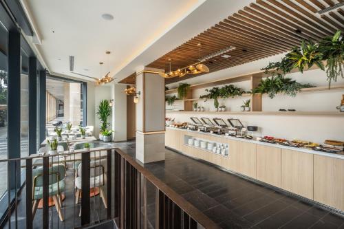 a restaurant with a bar with plants on the wall at Hotel LIVVO Lumm in Las Palmas de Gran Canaria