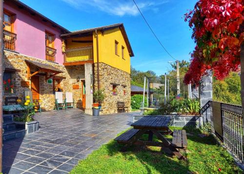 a picnic table in front of a building at La Cabana´l Cachican in Cangas del Narcea