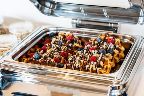 a tray of food withecake and berries on it at Hotel LIVVO Lumm in Las Palmas de Gran Canaria