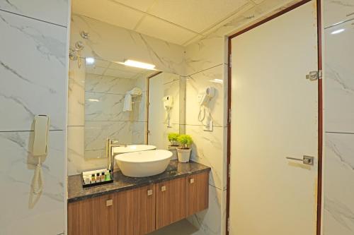 a bathroom with a sink and a mirror at Krishnavalsam Regency in Guruvāyūr