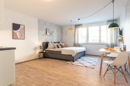 a bedroom with a bed and a table in it at NEU☆Business Apartment☆Messe/Airport☆Tiefgarage in Leinfelden-Echterdingen