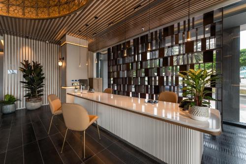 a lobby with a long counter with chairs and books at Hotel LIVVO Lumm in Las Palmas de Gran Canaria