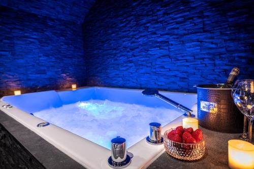 a jacuzzi tub with a bottle of wine and strawberries in it at La Bastide du Rocher Boutique Hôtel & Spa in Roquebrune-sur-Argens