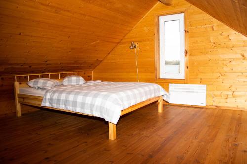 a bedroom with a bed in a wooden cabin at Lāde in Lādezers