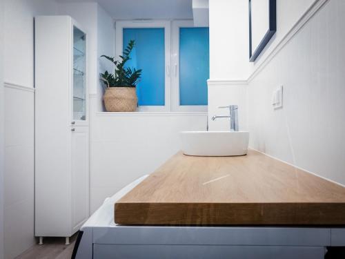 a bathroom with a sink on a wooden counter at APARTAMENT DLA 2 OSÓB - Fahrenheita 2 in Gdańsk