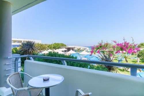a balcony with a table and chairs and a view of the ocean at Kos Palace in Tigaki