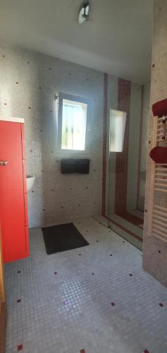 un bagno vuoto con finestra e pavimento piastrellato di Chambre à Bouzigues dans villa individuelle a Bouzigues