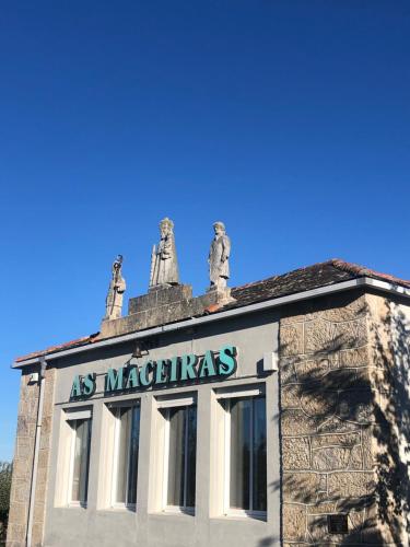 a building with two statues on top of it at HOTEL AS MACEIRAS in Trives