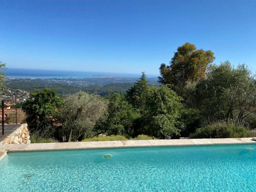 a swimming pool with a view of the ocean at Les Mas d'Azur Appartement in Vence