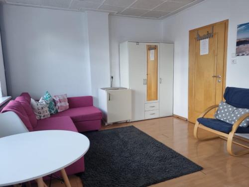a living room with a purple couch and a table at Ferienunterkunft auf Sylt in Westerland (Sylt)
