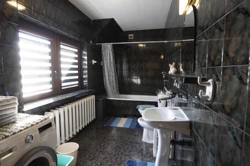 a bathroom with a sink and a washing machine at KURP - Pokoje Gościnne,zakaz spożywania alkoholu! in Ostrołęka
