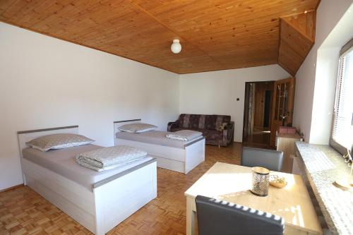 uma sala de estar com duas camas e um sofá em KURP - Pokoje Gościnne, Noclegi em Ostrołęka