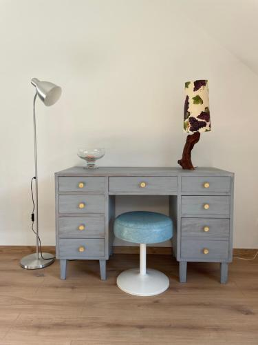 escritorio con silla azul y lámpara en Ferienwohnung „Zur alten Brauerei“, en Mesenich