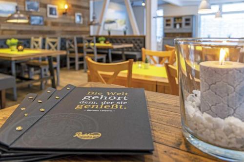 a candle and a book on a table with a restaurant at Hotel sleep & go in Bad Hersfeld