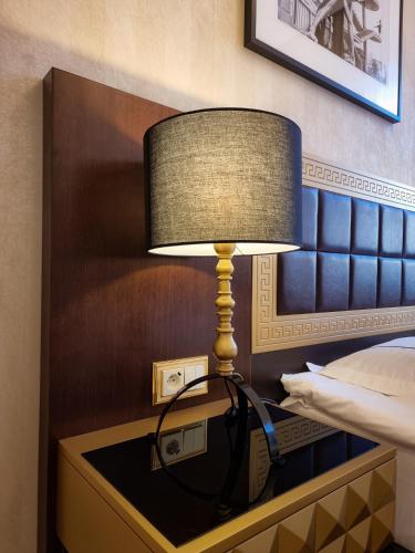 a lamp on a table next to a bed at Tiffi Old Town Hotel in Warsaw
