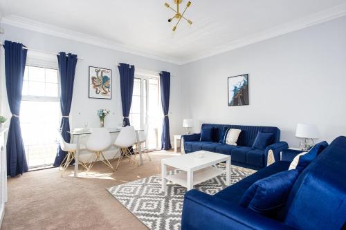 a living room with a blue couch and a table at Compass Point by Sorted Stay in Southend-on-Sea