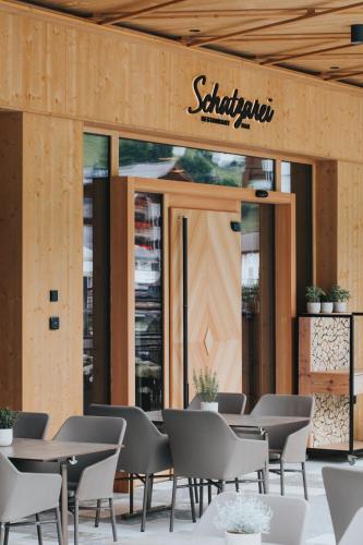 a restaurant with tables and chairs in front of a building at Hotel Tauernhof in Grossarl