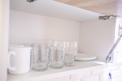 a shelf with glass jars and plates on it at Passenger Hostel in Novi Sad