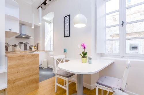 a kitchen and dining room with a white table and chairs at Leonarda Baroque House - Old Town in Dubrovnik