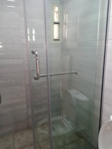 a shower with a glass door in a bathroom at Professionals Friendly with Work Station PS5 & near Beaches in Lekki