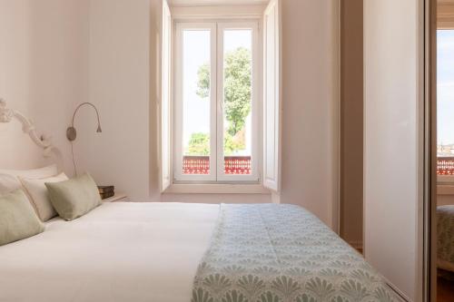 um quarto com uma cama e uma grande janela em Alfama Amazing Scenic River and City View Charming apartment With 2 bedrooms and AC 19th Century Building em Lisboa