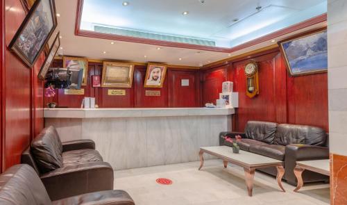 Al Karnak Hotel في دبي: غرفة انتظار مع كراسي جلدية وطاولة