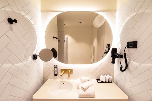 a bathroom with a sink and a mirror at Hotel Grand Koper in Koper