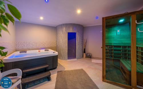 a large bathroom with a tub and a shower at Apartments Wellness in Drenje