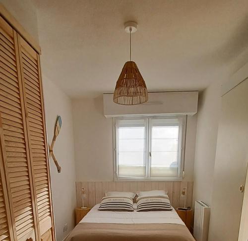 a bedroom with a bed and a large window at T2 cosy/balcon sud ouest/300m-mer/Villers sur Mer in Villers-sur-Mer