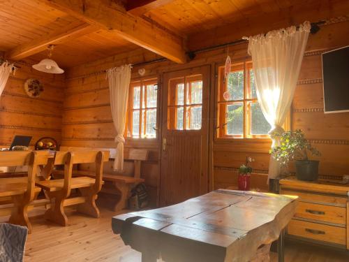 a dining room with a table in a log cabin at SkiBajkowa Chata in Szczyrk