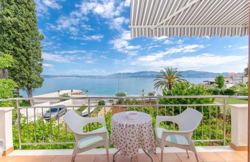 a table and chairs on a balcony with a view of the water at Apartments Jerko in Sutivan