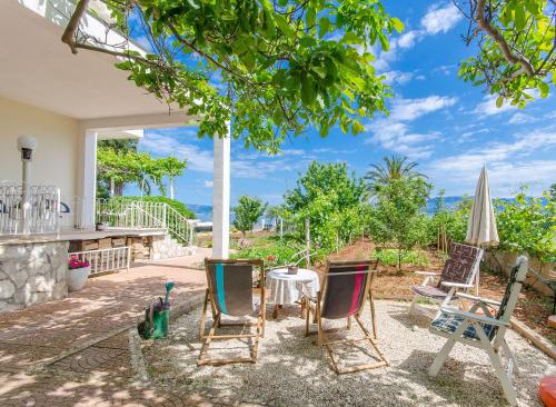 a patio with chairs and an umbrella and a table at Apartments Jerko in Sutivan