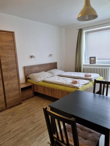 a bedroom with a bed and a dining room table at Apartmány Relax in Ladná