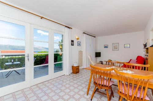 a living room with a table and chairs and a balcony at Apartment Neven in Trogir